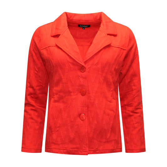 Voorzijde van Sunday Vest Senna met recht model, lange stretchmouwen, kraagje met knoopsluiting, steekzakjes en rode reliëfstof.